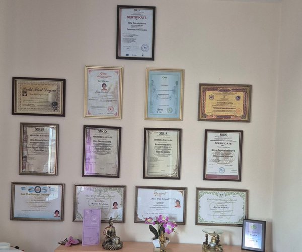 Wall of 15+ professional massage therapy certificates