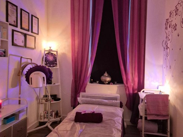 Treatment room with calming purple ambiance and floral decor