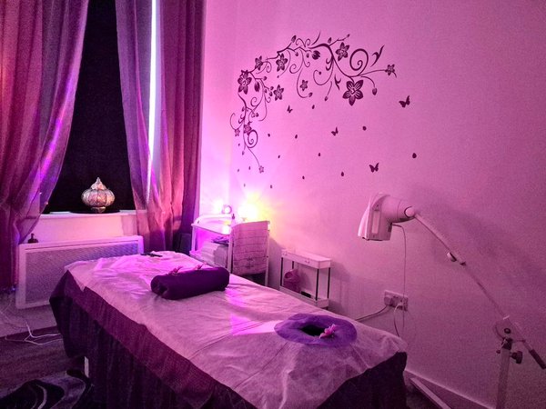 Massage room with purple lighting and decorative wall art