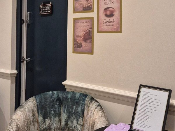 Welcoming reception area with stylish chair and treatment menu